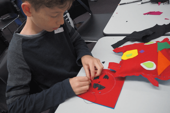 Boy sewing a running stitch