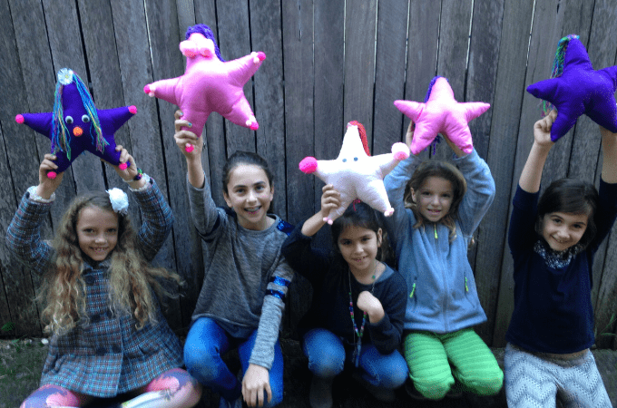 children showing their sewing projects