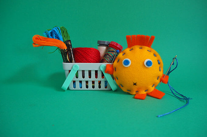 A little soft toy with a basket full of different sewing threads for kids?